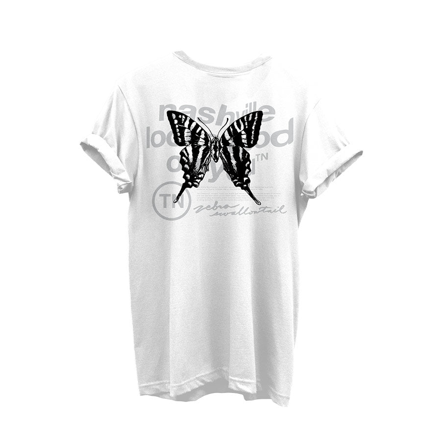 White shirt with rolled sleeves on a white background. The back of the shirt shows a black Zebra Swallowtail butterfly on top of wavy gray text. There is a circle TN in the lower left of the design. The Zebra Swallowtail is Tennessee's official state butterfly. 