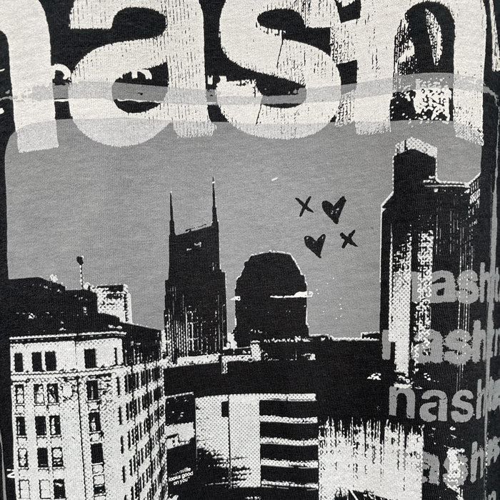 Dark shirt on white background. There is a graphic arts styled photo of Nashville,TennesClose up look at gray and white t-shirt artwork of Nashville, Tennessee. Hearts and X's are drawn near the Batman Building. The screen printed artwork is distressed and layered to look like an old, faded band tee.