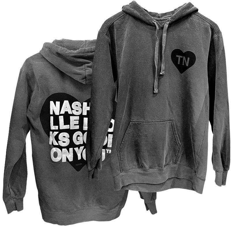 Front and back sides of gray hooded sweatshirt on a white background. Backside has a black heart with white text printed on top that reads nashville looks good on youᵀᴺ in wrapped text. The front side of hoodie has a small black heart with letters TN on chest. TN is the abbreviation of Tennessee.