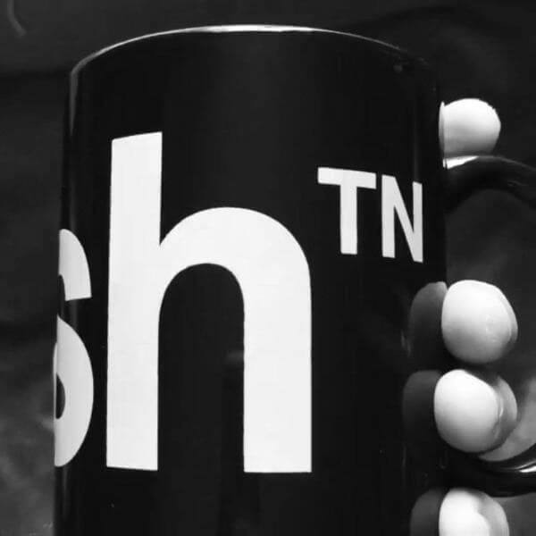 Super closeup of black coffee mug with white letters. The logo has a superscript TN next to the letter h in nash. This superscript TN looks like both a trademark and is the abbreviation for Tennessee.
