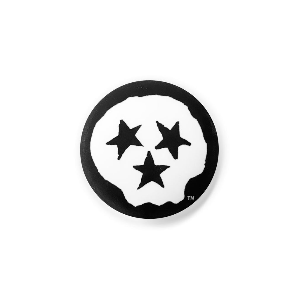 Black round lapel pin button on a white background. The pin has a white skull and three black stars. Tennessee is known as the Tri-Star state and the skull's stars represent both a face and the three grand divisions of Tennessee: East, Middle and West. 