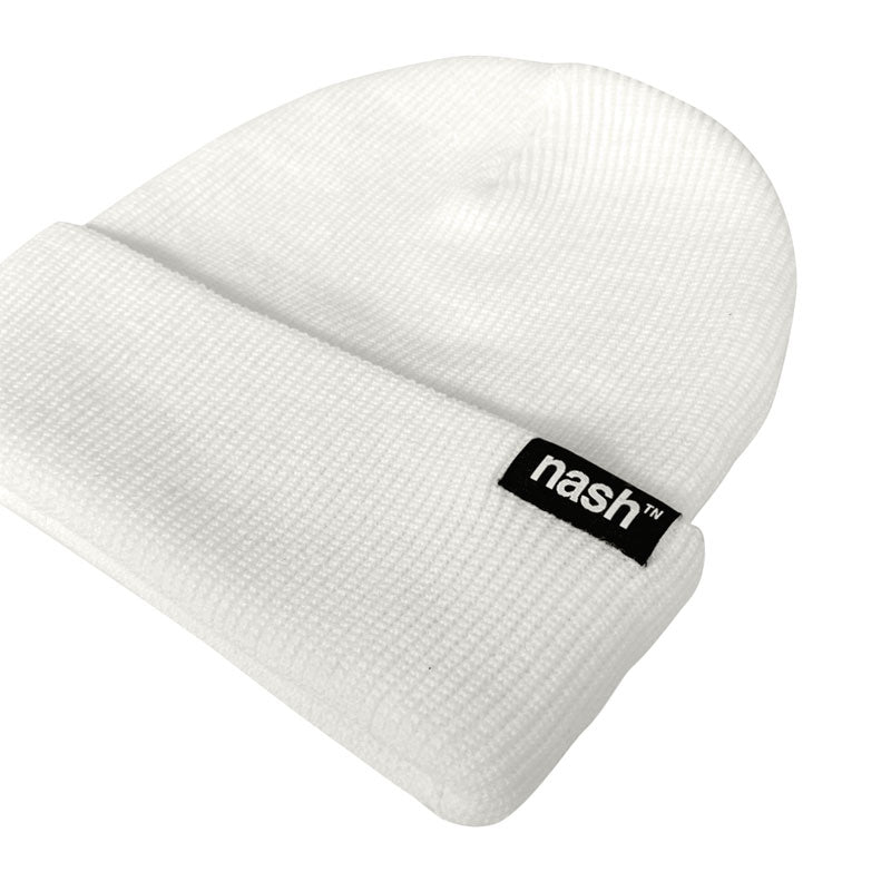 White beanie on white background shown at an angle. The beanie has a folded cuff with a black tag on the right side. The tag has white letters on it that says nashᵀᴺ