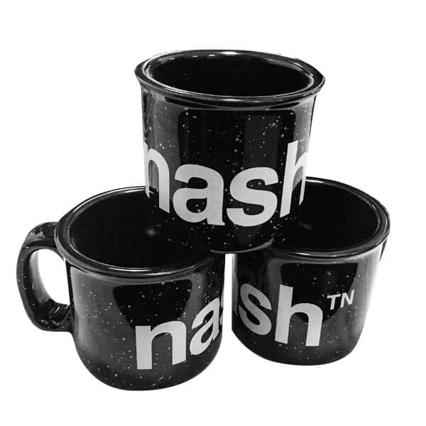 Stack of three black mugs with white speckles and words on a white background. A campfire style mug with logo nashᵀᴺ  in white wraps around the mug.