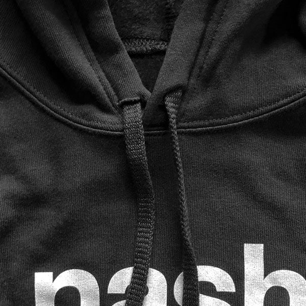 Close up detail of black hooded sweatshirt hood drawstrings. White, partial logo text is shown at bottom of photo.