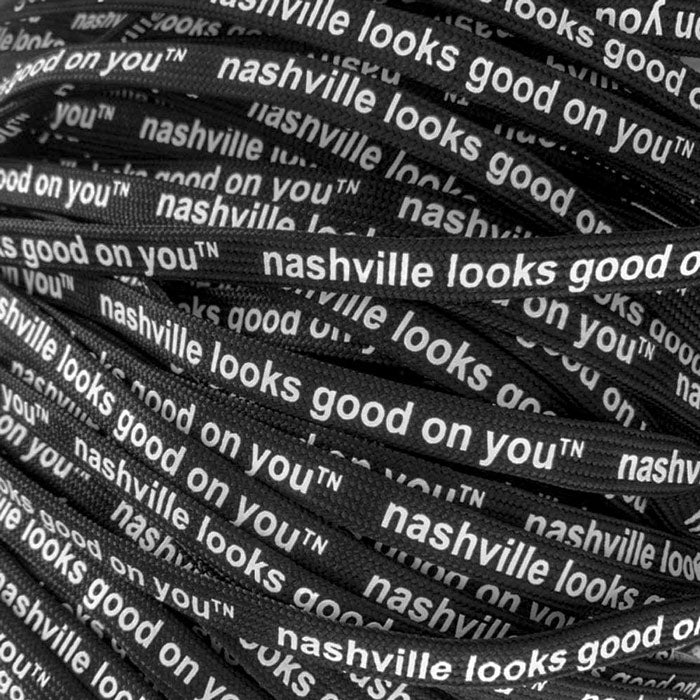 A  jumbled pile of black laces with white letters. On each lace, nashville looks good on youᵀᴺ is printed.