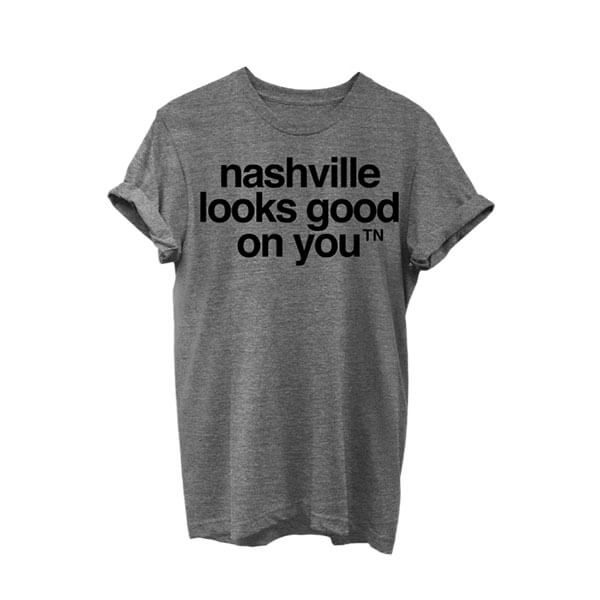 Gray crewneck short sleeve T-shirt with black text on white background. The sleeves are rolled. The nashᵀᴺ slogan, nashville looks good on youᵀᴺ is printed in black and centered on shirt.
