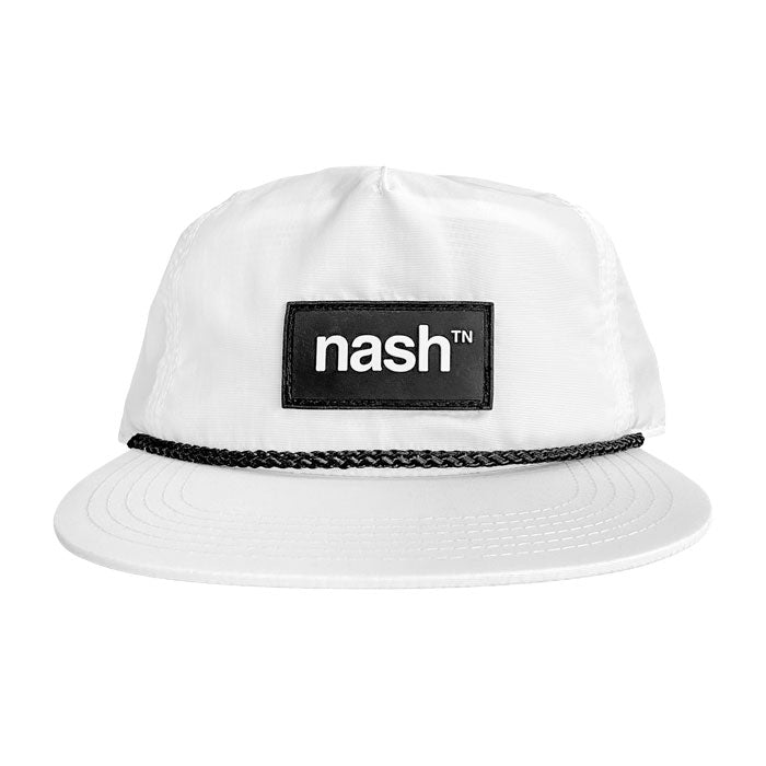 White baseball cap with black rope and black patch on white background. Black rectangle patch has white nashᵀᴺ  logo.