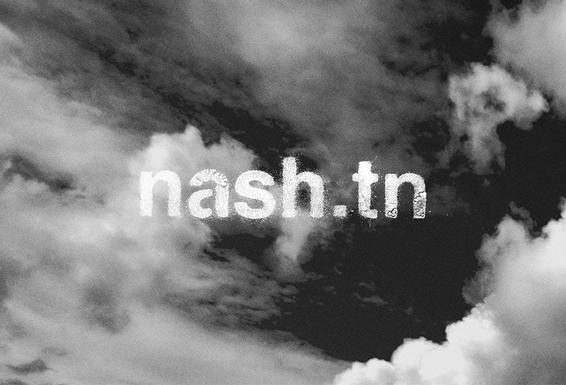 A black and white photo of clouds with white, textured print of nash.tn appearing in the front center.