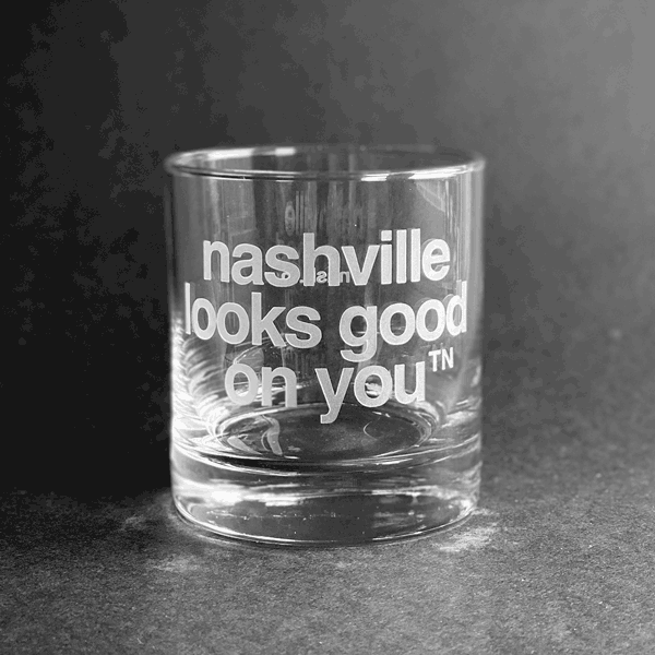 Spinning clear frosted glass on dark background. Nashville looks good on you etched into rocks glass