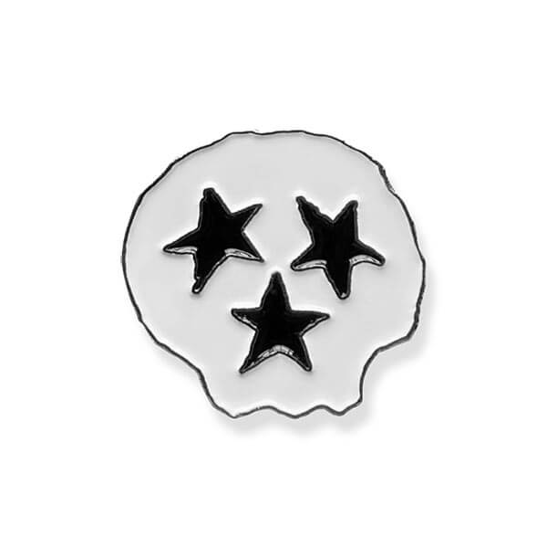 White skull shaped fashion pin on white background. The skull is outlined in black and are three black stars- two for eyes and one for the mouth. Tennessee is known as the Tri-Star state and the skull face is a nod to this.